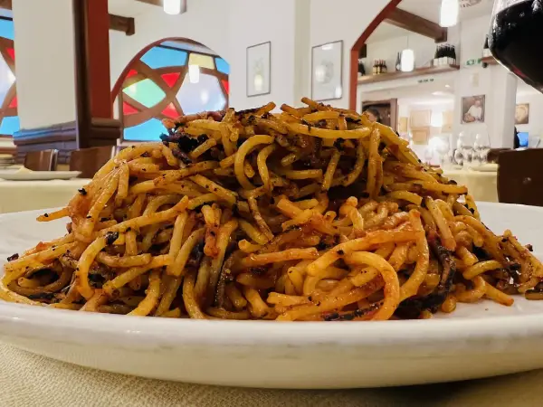 Un piatto di spaghetti con pomodoro e verdure, un assaggio di cosa si mangia a Bari.