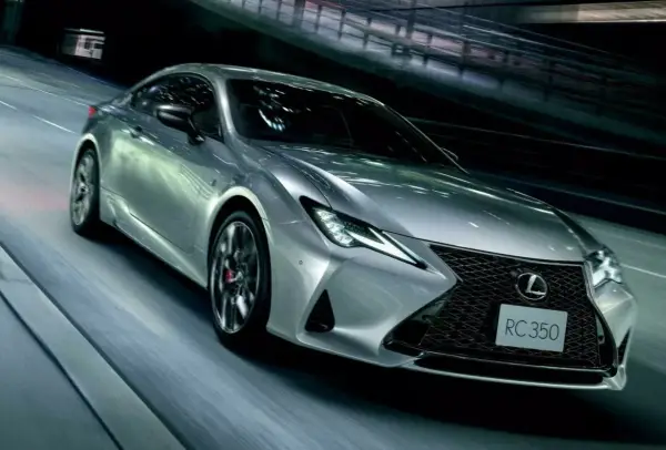 Srebrny Lexus RC 350 pędzi nocą przez tunel, jego światła przecinają mrok.