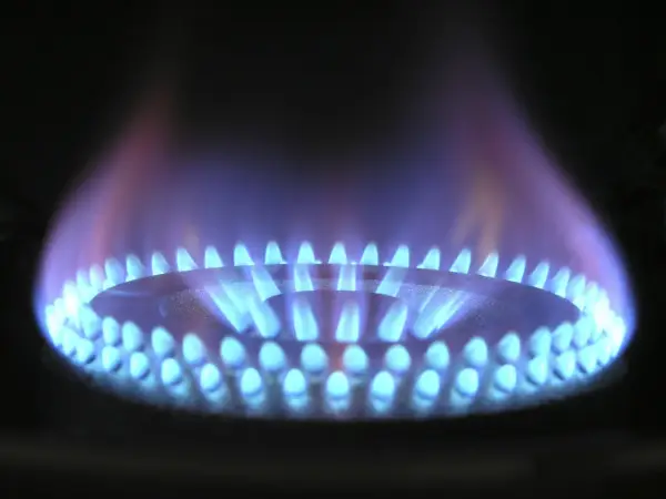 Fiamma blu su fornello a gas, che illumina la cucina. Un esempio di combustione efficiente di gpl metano.