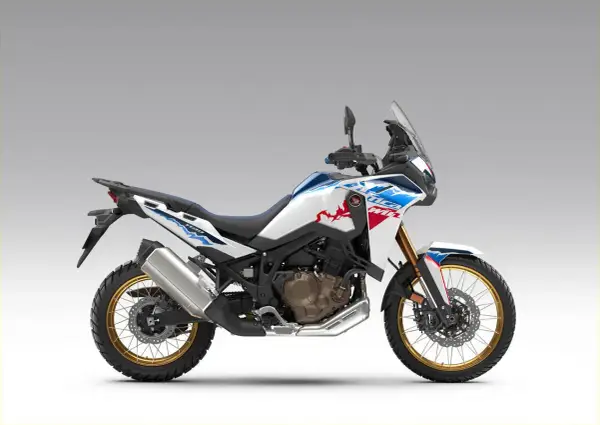 Nowy motocykl Honda Africa Twin 1100 w białym malowaniu z niebieskimi i czerwonymi akcentami, gotowy na przygodę.
