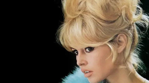 Icono de los moda peinados de los 60 con cabello rubio voluminoso y maquillaje dramático.