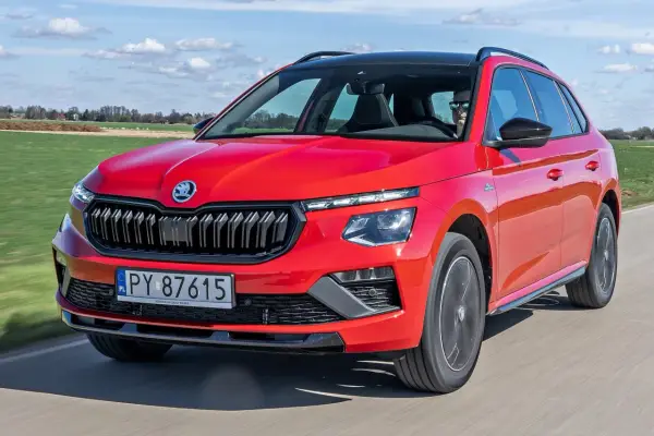 Czerwona Skoda Kamiq w ruchu, idealna na wakacyjne wyjazdy. Sprawdź atrakcyjną skoda kamiq cena.