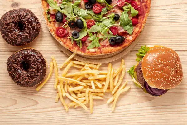 Pizza, burger, frytki i pączki z czekoladą – uczta pełna tłuszczów nasyconych.