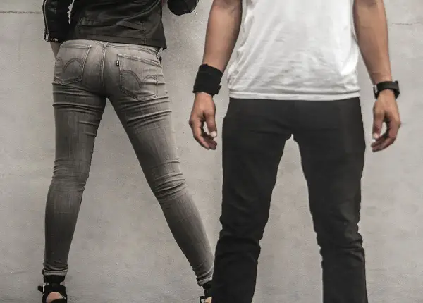 Szara, dopasowana para jeansów, widać metkę Levi's. Czy to rozmiar w25? Obok mężczyzna w czarnych spodniach.
