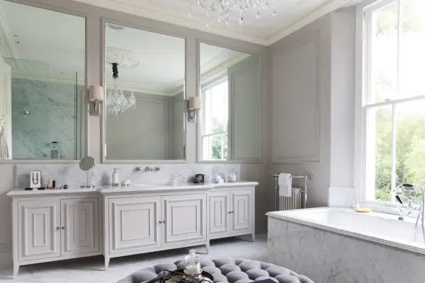 Ett lyxigt badrum med marmor, dubbla handfat, stor spegel och ett badkar. Perfekta inredningstips badrum för en elegant känsla.