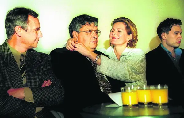 Lew Rywin, otoczony przez ludzi, z kobietą obejmującą go czule.