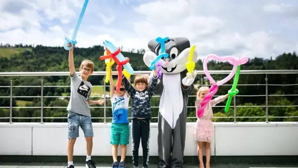 Dzieci z animatorami w strojach postaci z balonów tworzą miecze i serca. Wspaniałe beskidy atrakcje dla dzieci na wakacjach.