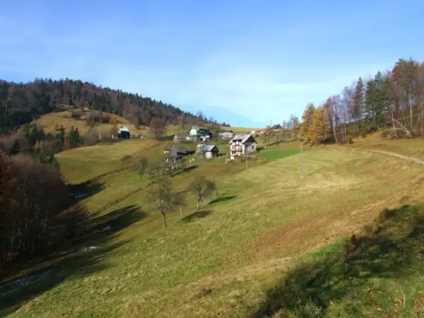 Jesienne krajobrazy Krynica Zdrój szczyty. Domy na zboczach, lasy i łąki.