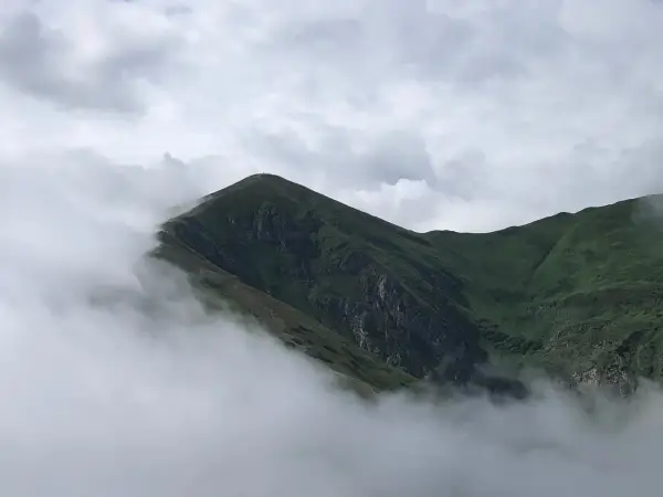 Mgliste szczyty górskie, gdzie chmury otulają zielone zbocza. Widok zapiera dech w piersiach, jakby raki w góry wznosiły się ku niebu.