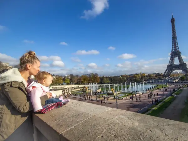 Madre y bebé disfrutan de la Torre Eiffel y las fuentes en Francia con niños.