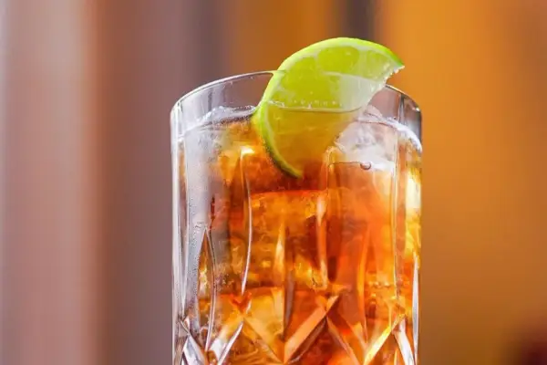 Orzeźwiający Long Island drink z lodem i plasterkiem limonki, idealny na letnie wieczory.