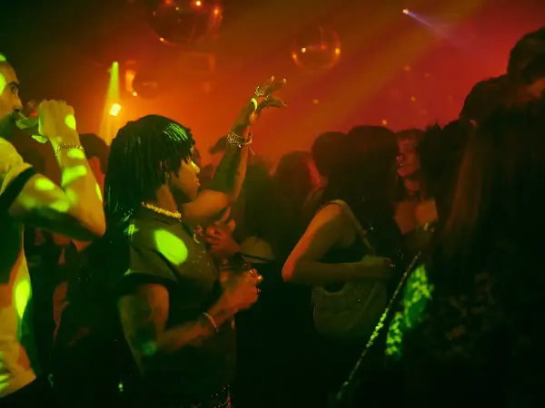 Persone che ballano in un locale notturno, luci stroboscopiche e musica alta: il vero clubbing significato.