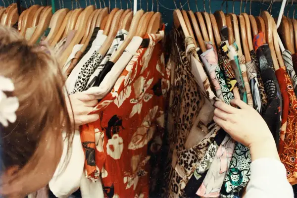 En person letar efter vilken stil har jag bland färgglada kläder med mönster som leopard och blommor.