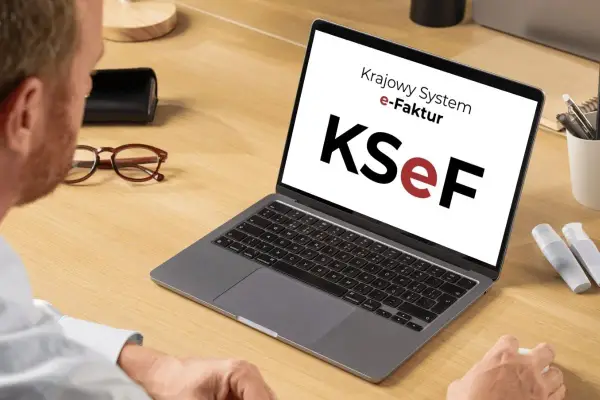 Mężczyzna pracuje przy laptopie z logo KSeF. Ułatwia to księgowanie faktur kosztowych.