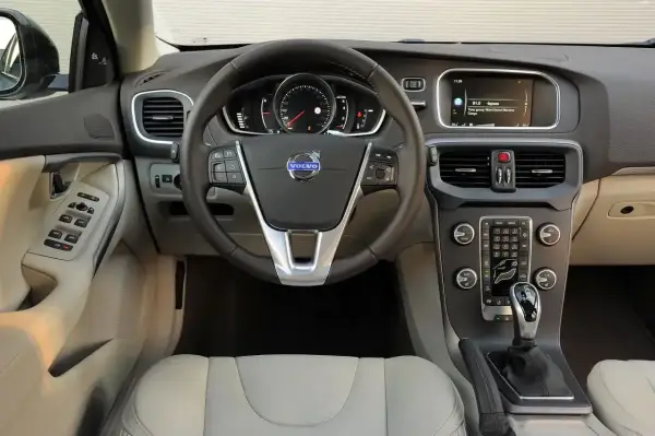 Wnętrze Volvo V40, które wielu kierowców chwali w swoich **volvo v40 opinie**. Widoczna kierownica, deska rozdzielcza z ekranem i konsola środkowa.