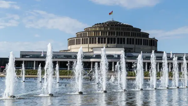 Wrocławska Hala Stulecia, jeden z obiektów UNESCO w Polsce, z fontannami w letni dzień.