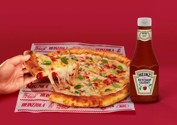Ciepła pizza z ciągnącym serem i bazylią, obok butelka łagodnego ketchupu Heinz – idealny duet do każdego kęsa.