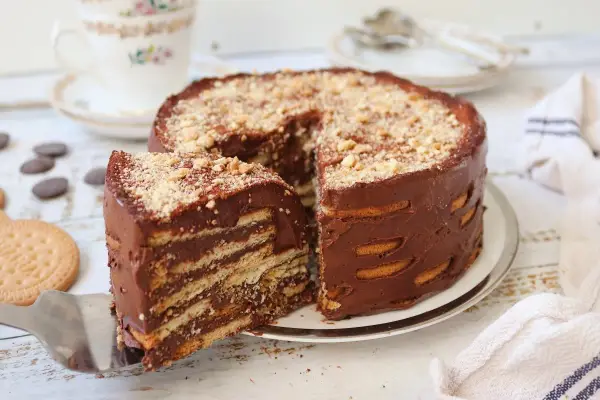 Deliciosa marquesa de chocolate, con capas de galletas y crema de cacao, espolvoreada con frutos secos.