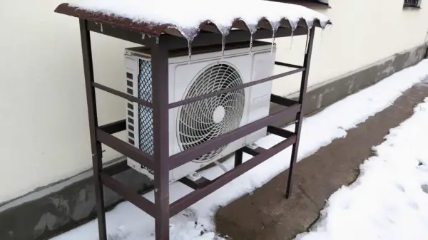 Unité extérieure de pompe à chaleur grand froid sous un abri enneigé. Avis sur sa performance en hiver.
