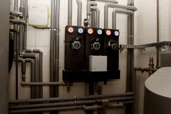 System grzewczy z pompami i manometrami. Zastanawiasz się, jakie rury do pieca węglowego wybrać? Tutaj widzisz izolowane rury i elementy instalacji.