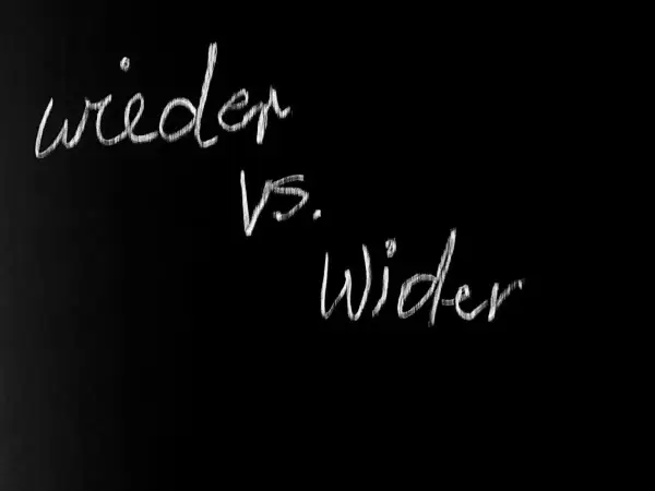 Kreide auf schwarzer Tafel: "wieder vs. Wider". Eine Frage, wie wird wieder geschrieben, wird hier visuell thematisiert.