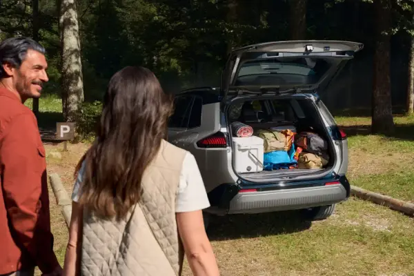 Para wyładowuje bagażnik Toyoty RAV4, gotowa na przygodę. Wymiary bagażnika pozwalają na spakowanie wszystkiego.