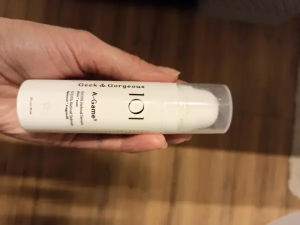 Dłoń trzyma serum Geek & Gorgeous A-Game 0.05% Retinal. Skóra wygląda na nawilżoną i promienną.