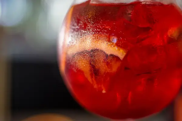 Orzeźwiający Martini Fiero drink z lodem i plasterkiem pomarańczy, skraplający się od zimna.