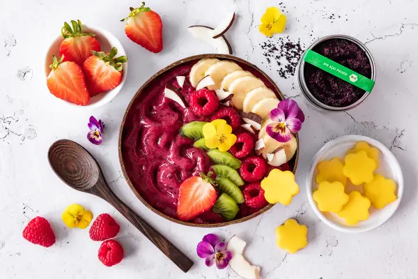 Ein farbenfrohes Acai Bowl Rezept mit frischen Beeren, Bananen, Kiwi, Kokos und essbaren Blüten. Perfekt für einen gesunden Start!