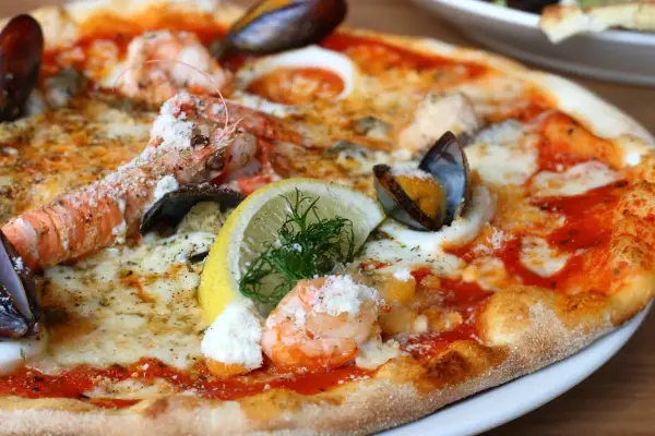 Wykwintna pizza z krewetkami, małżami i cytryną – być może najdroższa pizza na świecie, kusząca bogactwem owoców morza.