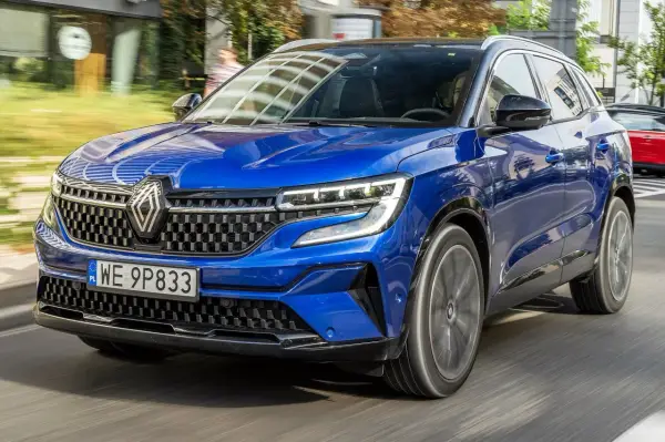 Błękitny Renault Austral pędzi po drodze, jego nowoczesny design i sportowy charakter przyciągają wzrok.