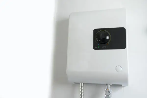 Scaldabagno elettrico istantaneo: pro e contro. Un dispositivo bianco montato a parete con un quadrante nero e indicatori luminosi.
