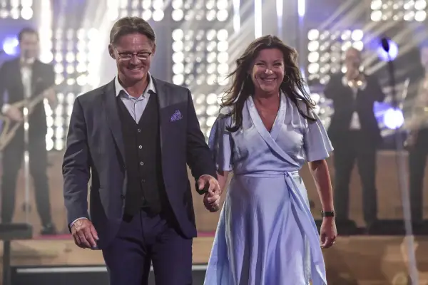 Lotta Engberg och ett leende raffset på scenen, med ett band i bakgrunden.