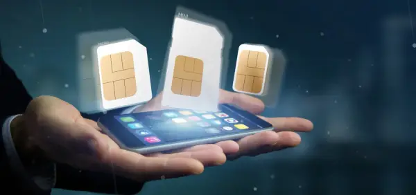 Dłoń trzyma smartfon, nad którym unoszą się karty SIM. Rozpocznij swoją przygodę z siecią Play – rejestracja karty SIM Play nigdy nie była prostsza!