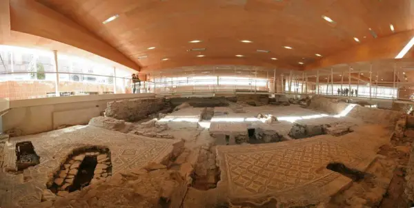 Resti archeologici della domus del chirurgo, con pavimenti a mosaico ben conservati sotto una moderna copertura in legno e vetro.