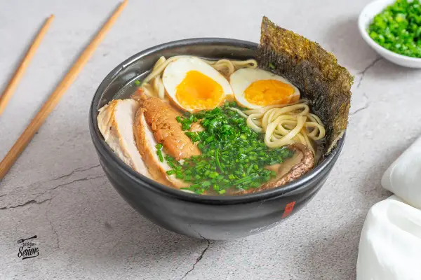 Un delicioso tazón de ramen con fideos, huevo cocido, carne de cerdo, cebollín y alga nori. Una tentadora receta ramen lista para disfrutar.