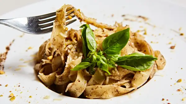 Wide tagliatelle z parmezanem i bazylią, kuszące aromatem, który zdradza, jaki smak ma trufla.