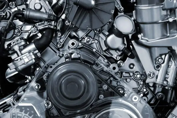 Detalle de un motor de cuatro tiempos, con correas, poleas y componentes metálicos pulidos.