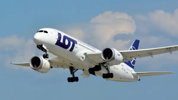Boeing 787-8 Dreamliner LOT, z widocznym logo i napisem "POLISH AIRLINES". Samolot wznosi się na tle błękitnego nieba z chmurami.