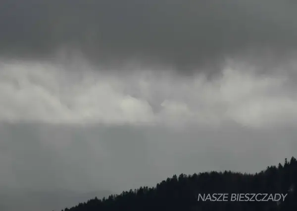 Mroczne chmury nad lasem zapowiadają deszcz. W Wetlinie znajdziesz atrakcje na deszcz, które umilą Ci pobyt.