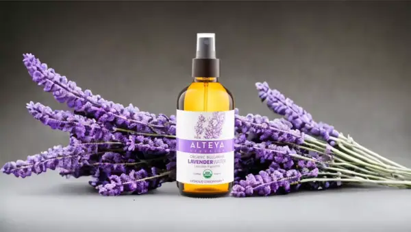 Butelka z organiczną wodą lawendową Alteya Organics otoczona bukietami fioletowej lawendy.