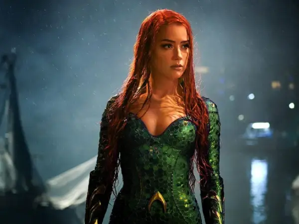 Amber Heard w zielonym kostiumie z filmu "Aquaman". Jej długie, rude włosy opadają na ramiona.