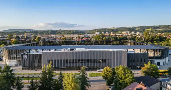 Nowoczesny stadion Sandecji w Nowym Sączu, otoczony zielenią i górami, gotowy na nowe emocje.