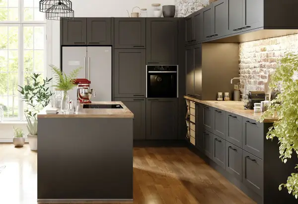 Cuisine gris anthracite avec un mur en briques apparentes. Un îlot central et des meubles sombres créent une ambiance moderne.