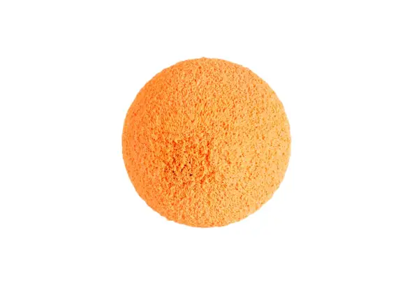 Une balle de nettoyage orange, texturée et spongieuse, prête à faire briller votre maison.