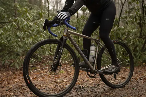 Cyclist adjusting saddle height to prevent calf pain.