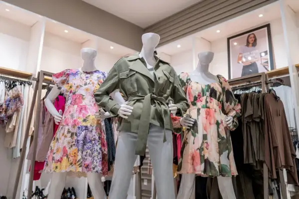 Manekiny w sukienkach w kwiaty i zielonej kurtce. To styl marki Scotch & Soda, znanej z kolorowych, letnich ubrań.