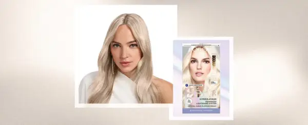 Mujer con pelo rubio platino, resultado de decoloración pelo. Caja de tinte L'Oréal Féria Hyper Platinum.