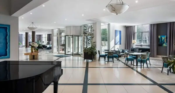 Eleganckie wnętrze hotelu Radisson Blu Wrocław z fortepianem, wygodnymi fotelami i stolikami.