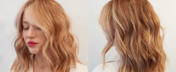 Mujer con cabello ondulado rubio fresa con reflejos dorados y rosados.